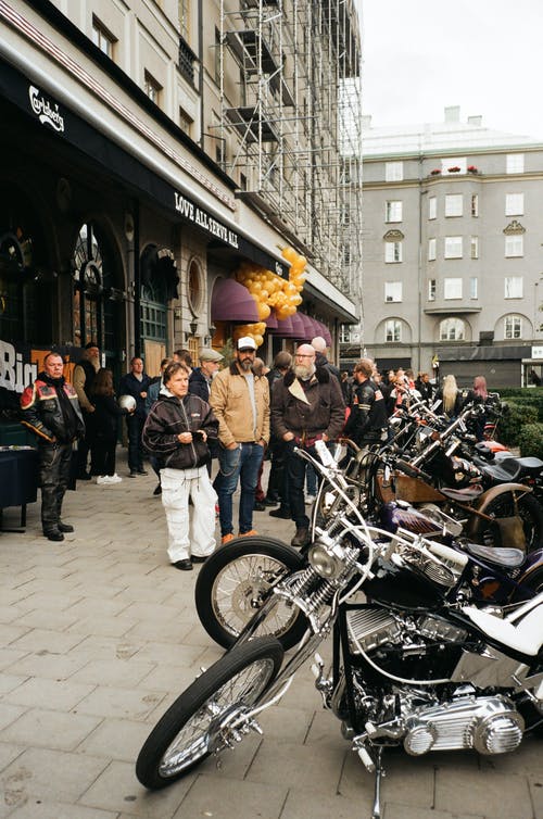 人们看着停放的摩托车 · 免费素材图片