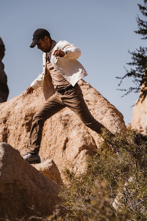 男子站在岩石上 · 免费素材图片