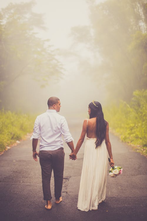 夫妇赤脚行走时手牵着手的照片 · 免费素材图片
