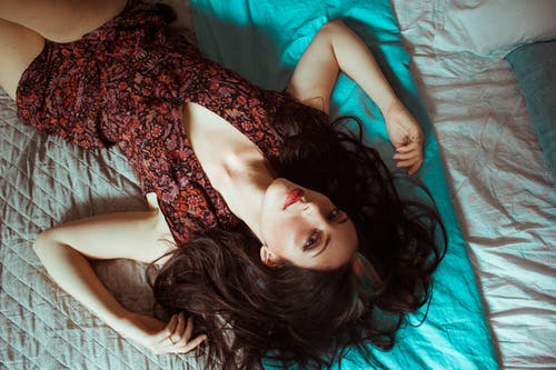 女人躺在床上的高角度照片 · 免费素材图片