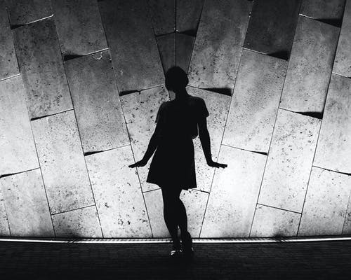 站在墙附近的人的单色照片 · 免费素材图片