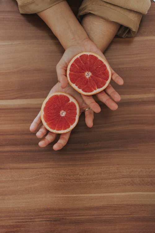 手上的葡萄柚片 · 免费素材图片