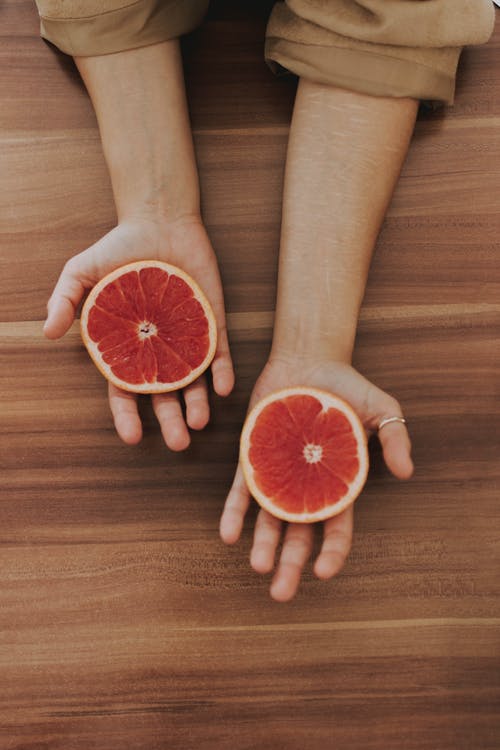 圆形切水果在人的手上 · 免费素材图片