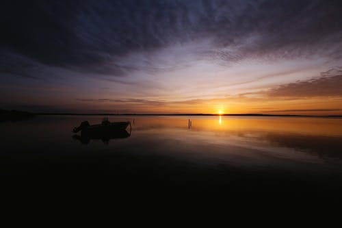 日出时在水体上划船 · 免费素材图片