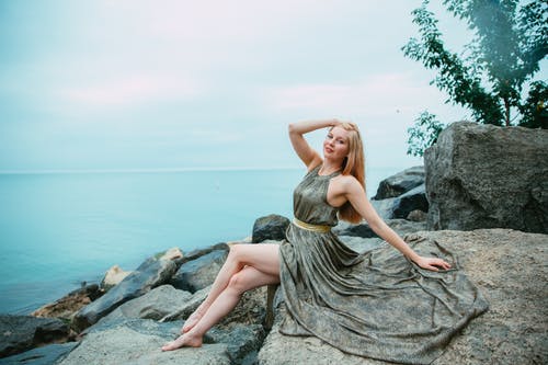 女人坐在一块岩石上 · 免费素材图片