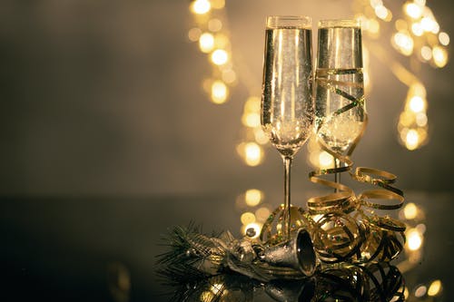 两个长笛杯装满起泡酒伍兹丝带和圣诞节装饰的特写镜头 · 免费素材图片