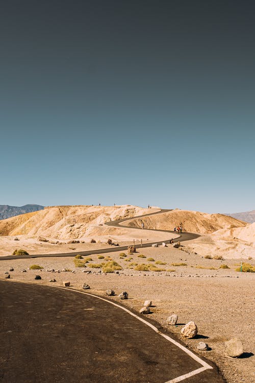 宽阔的曲折道路，在沙漠中蓝蓝的天空下 · 免费素材图片