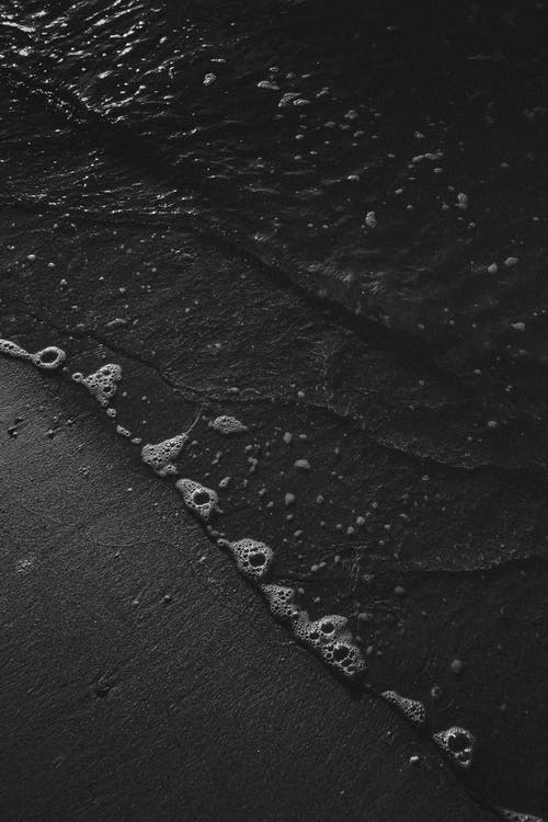 海浪拍打在岸边的灰度摄影 · 免费素材图片