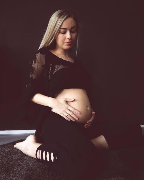 黑色衣服的下跪时跪在地板上的孕妇照片 · 免费素材图片