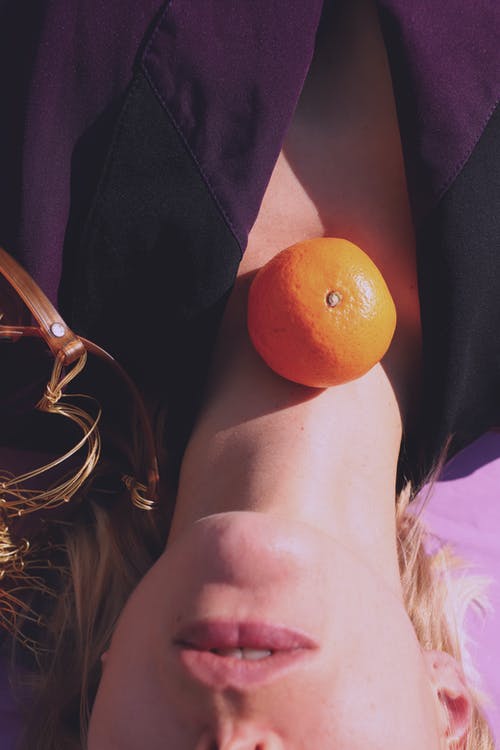 女人的脖子上的橙色水果 · 免费素材图片