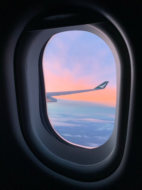 从飞机窗口的云层和飞机机翼的视图 · 免费素材图片