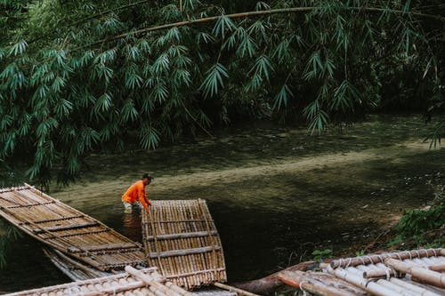 河里的人拉竹筏到水 · 免费素材图片