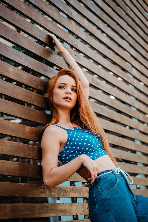 靠在墙上的女人的照片 · 免费素材图片