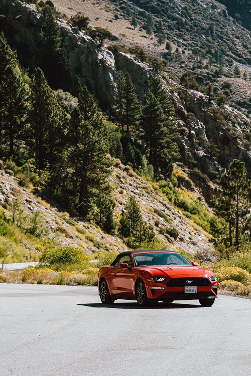 红色福特野马跑车在山路上 · 免费素材图片