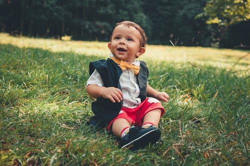 小男孩坐在草地上 · 免费素材图片