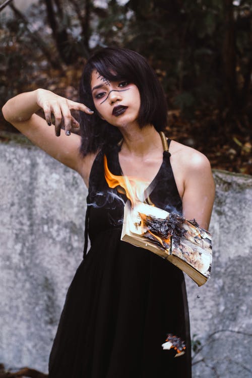 女人拿着本书着火 · 免费素材图片