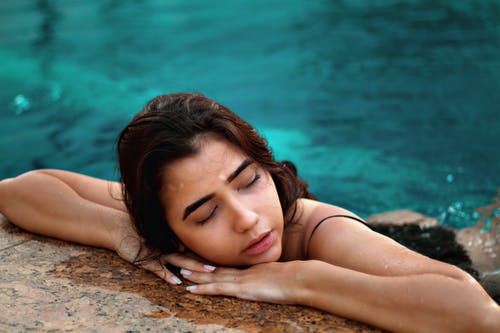 倾斜在混凝土表面上的女人的照片 · 免费素材图片