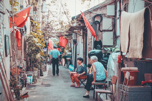 两个女人坐在胡同上 · 免费素材图片