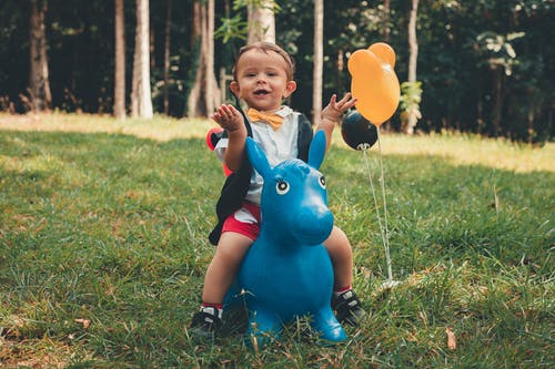 小男孩骑小马玩具骑 · 免费素材图片