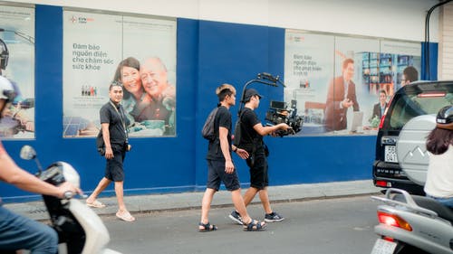 相机人员在路上行走的照片 · 免费素材图片