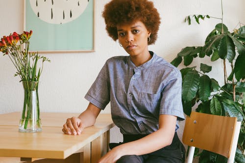 坐在植物附近的女人的照片 · 免费素材图片