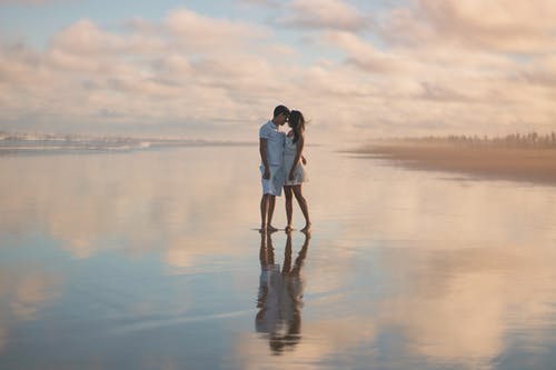 情侣站在水面上的照片 · 免费素材图片