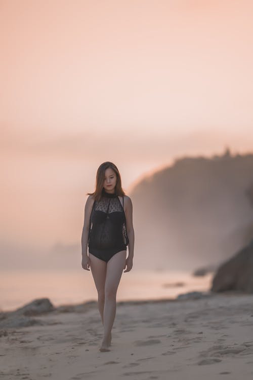 在海滩上散步的女人的照片 · 免费素材图片