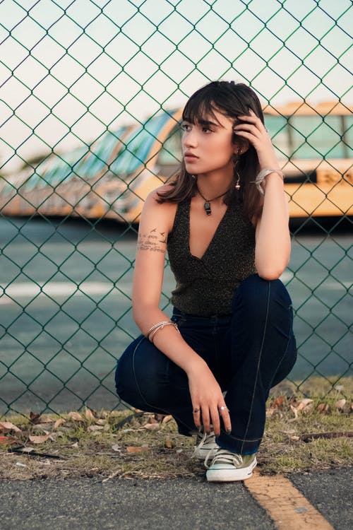 坐在栅栏旁边的女人 · 免费素材图片