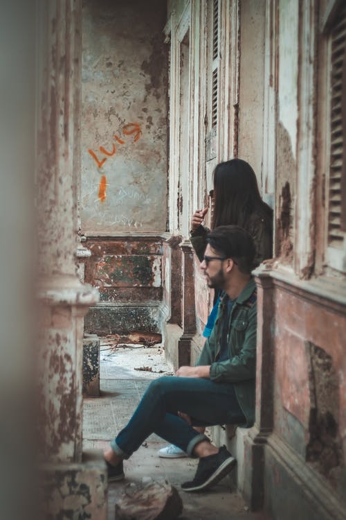男人坐在女人旁边的门上 · 免费素材图片