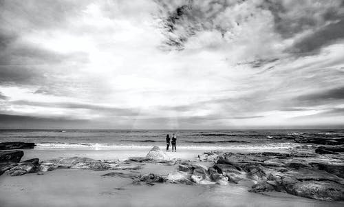两人站在海边 · 免费素材图片