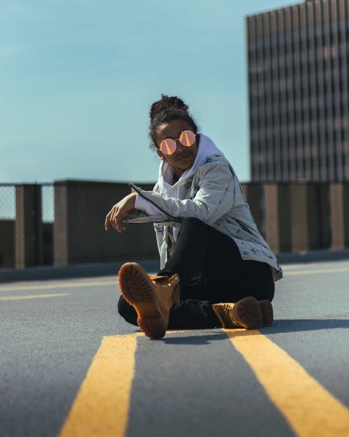 戴着墨镜坐在地上的男人 · 免费素材图片