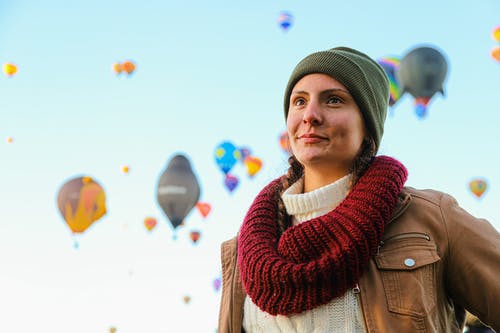 女人穿着绿色的无檐小便帽和针织的围巾 · 免费素材图片