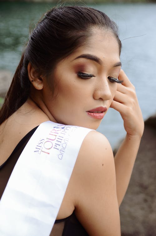 女人穿白色腰带，左手在脸上 · 免费素材图片