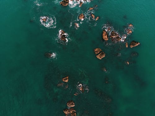 水上的岩层的顶视图照片 · 免费素材图片