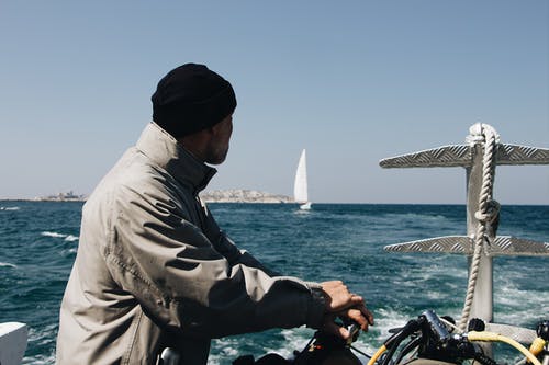 在海上的船只中穿灰色夹克的男人 · 免费素材图片