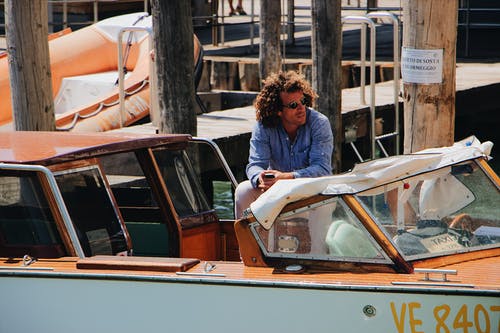 男子坐在游艇上的照片 · 免费素材图片