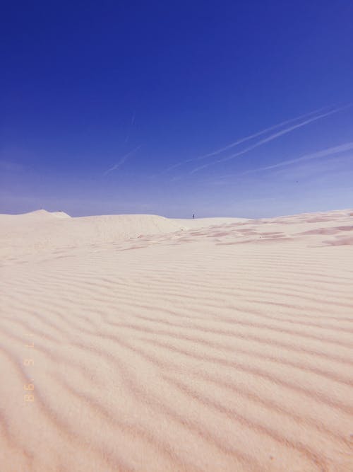 低角度拍摄的白色沙漠沙在湛蓝的天空下 · 免费素材图片