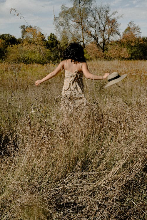 在草地上行走的女人的照片 · 免费素材图片