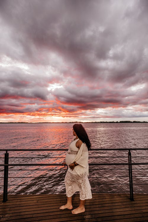 孕妇站在海湾的照片 · 免费素材图片