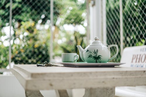 桌上的杯子旁边的茶壶 · 免费素材图片