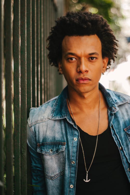 男子靠在栅栏上的照片 · 免费素材图片