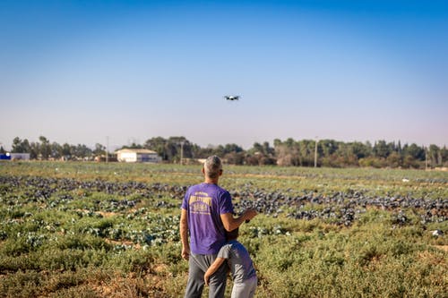 男人穿着紫色衬衫站在草地上 · 免费素材图片
