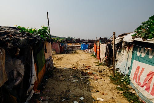 垃圾在房屋之间的通路上的照片 · 免费素材图片