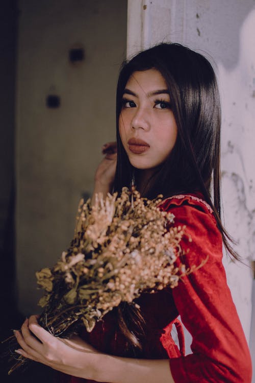 女人拿着米色花的照片 · 免费素材图片