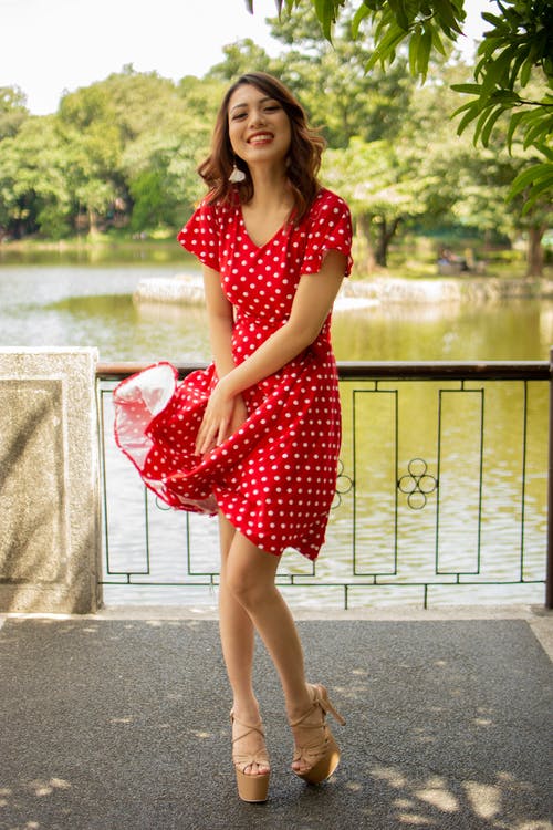 红色和白色的圆点裙的微笑女人 · 免费素材图片