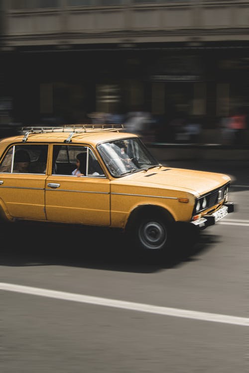 黄色轿车在道路上行驶 · 免费素材图片