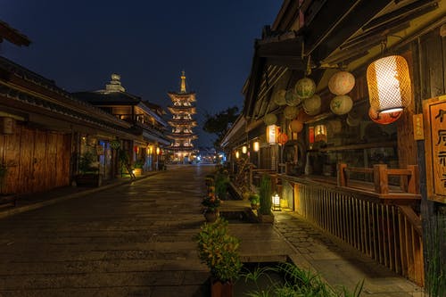 带有中国灯笼的棕色木制建筑物之间的空路 · 免费素材图片