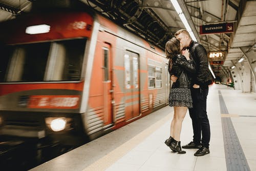 在地铁中运行火车旁边接吻情侣 · 免费素材图片