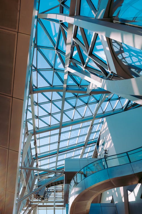 低角度拍摄的带有钢和玻璃面板天花板的现代建筑 · 免费素材图片