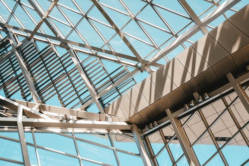 从钢和玻璃面板制成的现代建筑的内部低角度拍摄 · 免费素材图片